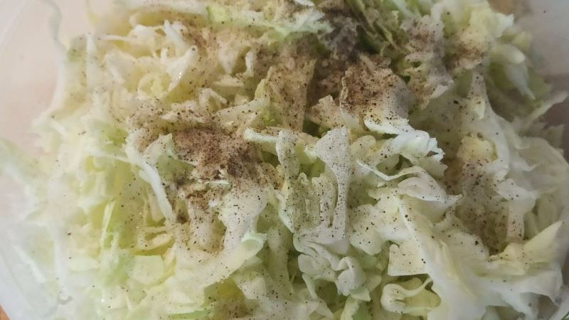 Свежая нашинкованная капуста, посыпанная молотым чёрным перцем