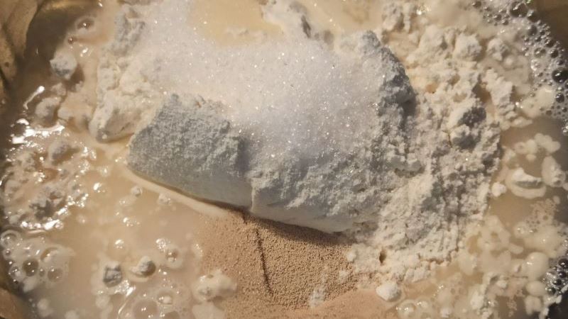 Ингредиенты для теста в миске: мука, сахар, дрожжи и вода