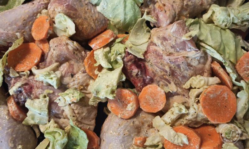 Сырые куриные окорочка с морковью и капустой в специях перед запеканием